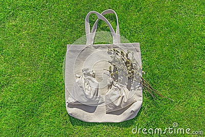 Bag from eco material â€“ unbleached cotton. Shopper feedbag on green grass. Plastic free natural fabric Stock Photo