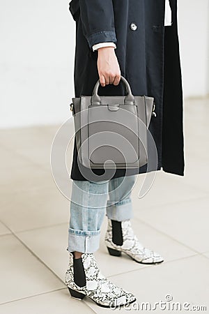 Bag in hand, blue jeans and blue raincoat Stock Photo