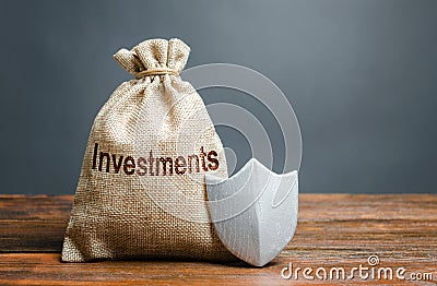 Bag with the inscription investment and shield. Guarantee of protection of foreign investment in the economy Stock Photo