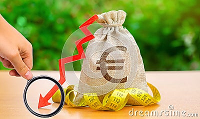 Bag with money and tape measure with arrow to down. Falling wages and welfare. Low profits and liquidity of investments. The Stock Photo