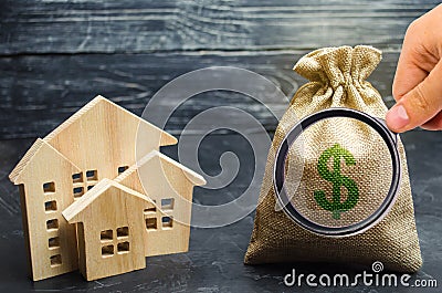 A bag with money and wooden houses. Selling a house. Apartment purchase. Real estate market. Rental housing for rent. Home prices Stock Photo