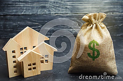 A bag with money and wooden houses. Selling a house. Apartment purchase. Real estate market. Rental housing for rent. Home prices Stock Photo