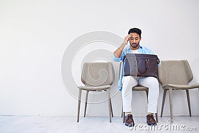 Bag, stress and man search in waiting room for interview, hiring and recruitment with lost resume in briefcase. Problem Stock Photo