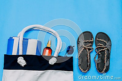 Bag with towels, sunglasses and beach accessories. Blue background. Copy paste, copy space Stock Photo