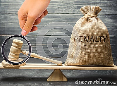 Bag with the word Penalty and gavel on the scales. Penalty as a punishment for a crime and offense. Fraud. The court`s decision. Stock Photo