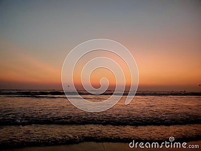 Baga beach with layered ocean waves during a colorful sunset. Stock Photo