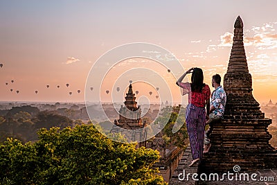 Bagan Myanmar, couple of men and woman looking at the sunrise on top of an old pagoda temple Stock Photo