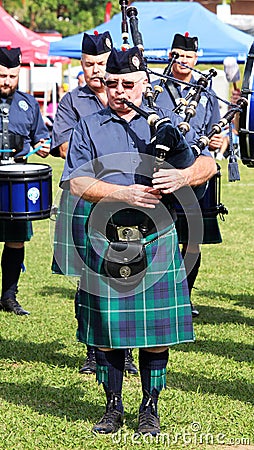 The bagpipers in traditional Scottish suits kilts with backpipe Editorial Stock Photo