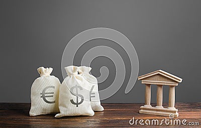 Bags of money and a bank building. Investments and deposits. Lending to businesses and projects, financing and banking services Stock Photo