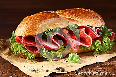 Baguette with fresh lettuce and salami Stock Photo