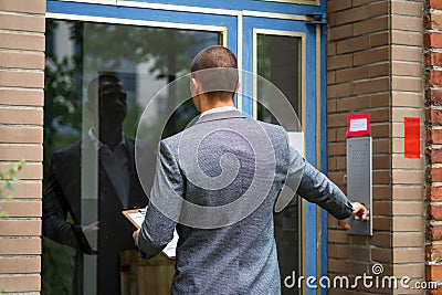 Bailiff Debt Collector Touching Doorbell. Confiscation Stock Photo