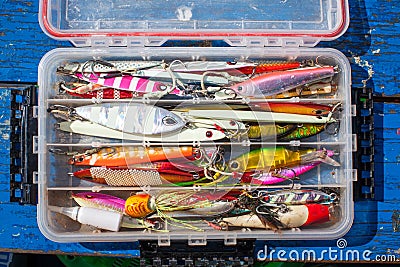 Bait jig for fishing for sea fish on plastic box on blue wood Stock Photo