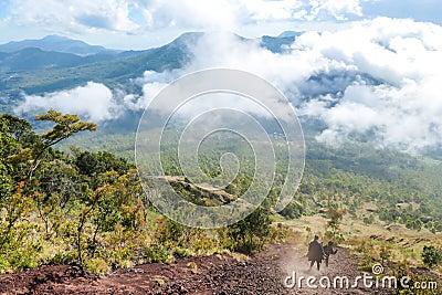 Bajawa - A couple going down a steep slopes of volcano Inierie Stock Photo