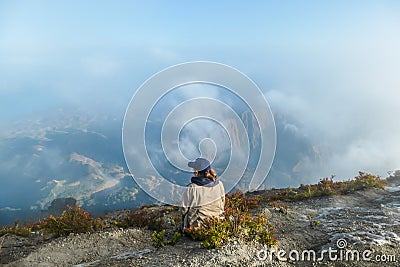 Bajawa - a girl sitting on the top of the volcano, admiring the view Stock Photo