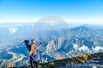 Bajawa - a girl standing on the top of the volcano, admiring the view Stock Photo