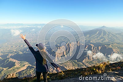 Bajawa - a girl standing on the top of the volcano, admiring the view Stock Photo