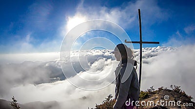 Bajawa - Girl standing on top of a volcano, surrounded by clouds Stock Photo