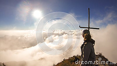 Bajawa - Girl standing on top of a volcano, surrounded by clouds Stock Photo