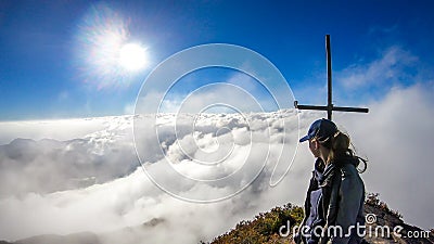 Bajawa - Girl standing on top of a volcano, surrounded by clouds Stock Photo