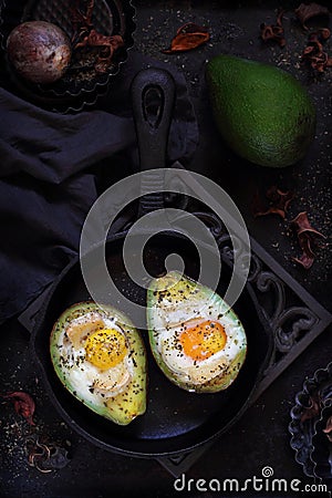 Baked avocado with egg on a dark background Stock Photo