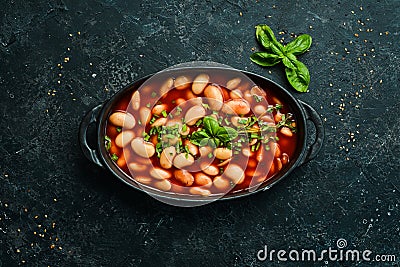 Baked beans in tomato sauce on a black stone plate. Stock Photo