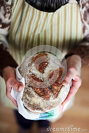 Baked bread, whole-grain sourdough loaf holding hands Stock Photo