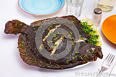Baked brill fish with lemon and greens Stock Photo