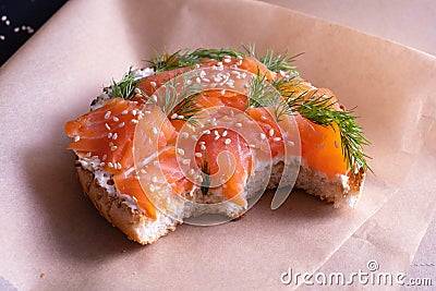 Baked bun, oiled with fresh cream, garnished with smoked fish trout and sprinkled with fresh dill and sesame seeds Stock Photo