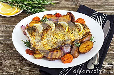 Baked carp with vegetables grilled on a white plate Stock Photo