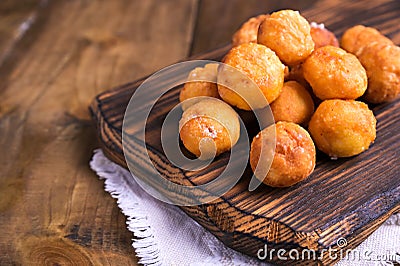 Baked castagnole with powdered sugar on wooden background. Street food, round biscuits with sugar for the carnival of Stock Photo
