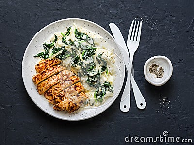 Baked chicken breast, mashed potatoes with creamy spinach on dark background, top view. Stock Photo