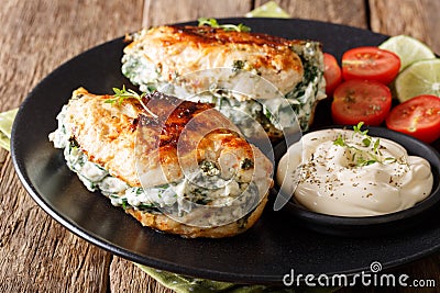 Baked Chicken fillet stuffed with cheese and spinach with sauce Stock Photo