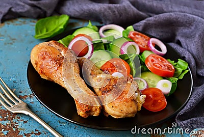 Baked chicken with a side dish of vegetable salad on the old, bl Stock Photo