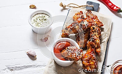 Baked chicken wings with sauce on white wood background Stock Photo