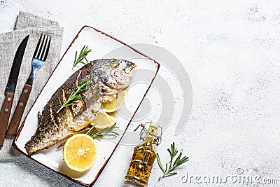 Baked dorado fish with lemon and rosemary top view. Stock Photo