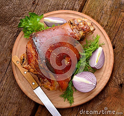 Baked Eisbein with wegetables on wooden board Stock Photo