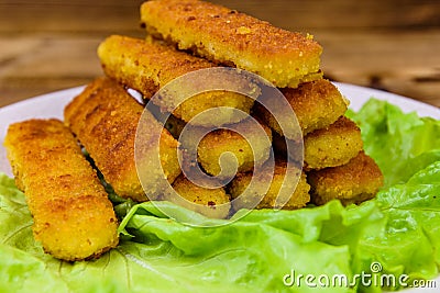 Baked fish sticks and lettuce leaves in a plate Stock Photo