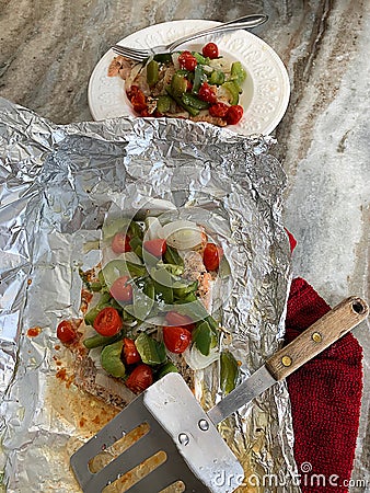 Baked in foil Salmon smothered in onions, peppers and tomatoes. Stock Photo