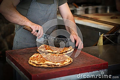 Baked lahmacun is a round, thin piece of dough topped with minced meat most commonly beef or lamb, minced vegetables and herbs. Stock Photo