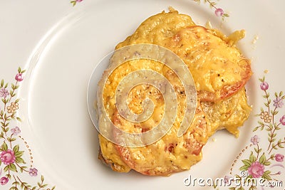 Baked meat with tomatoes and cheese on a white plate, view from Stock Photo