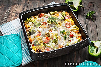 Baked pasta with broccoli and cheesy tomato sauce on wood background Stock Photo