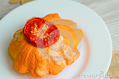 Baked patisson with tomato cheese. Pumpkin zucchini stuffed with meat on a white plate Stock Photo