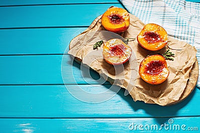Baked peaches with honey and cinnamon on blue wooden background. summer dessert. Top view and copy space. Stock Photo