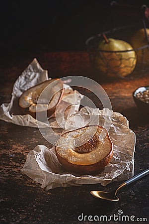 Baked pear with honey. Fresh homemade dessert. Food composition in a low key. Stock Photo