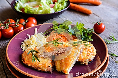 Baked pork cutlets coated in cheese and carrot with salad Stock Photo