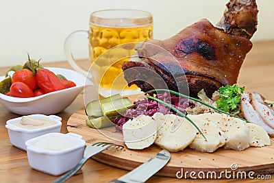 Baked pork shank and sauerkraut closeup on plate and beer on the table Stock Photo