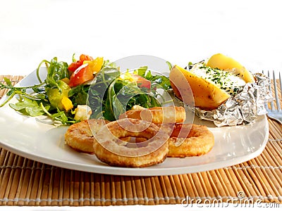 Baked foil potato with mixed salad,Calarmaris and sauce Stock Photo