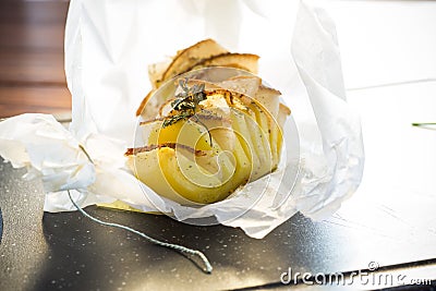 Baked potatoes stuffed with lard in baking paper. Stock Photo