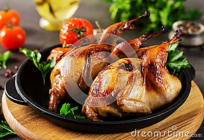 Baked quails in pan on a dark background Stock Photo