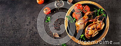 Baked quails in pan on a dark background. Stock Photo